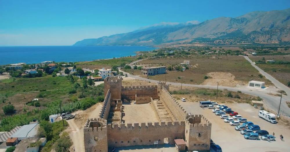 Aerial view of Frangokastello Castle in Crete, with the fortress walls, surrounding landscape, and the sea in the background | Cheap Car Rental